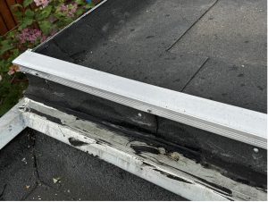 Dakaansluiting tussen een nieuwe uitbouw en een bestaand plat dak